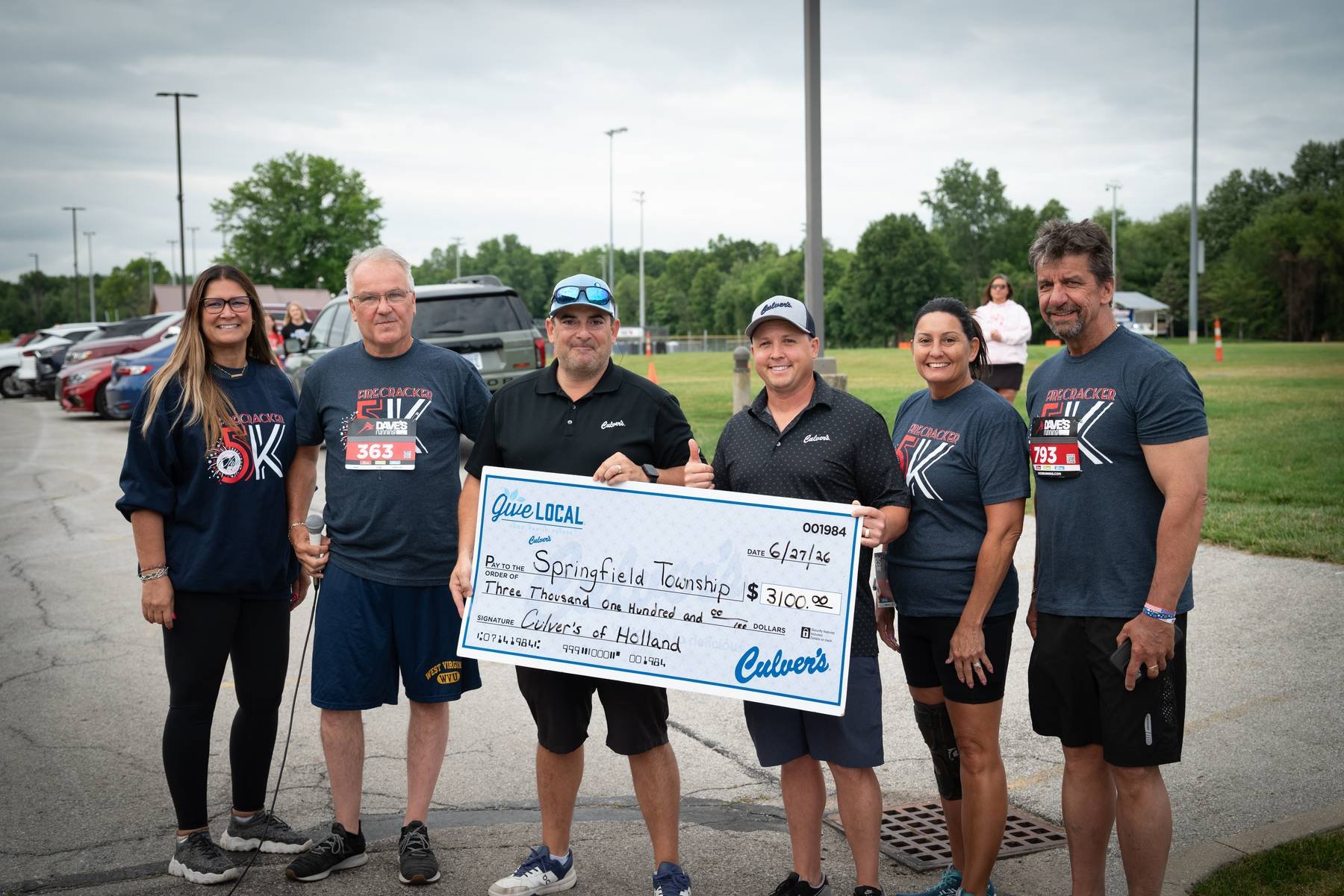 Sales Funnel Marketing presenting a charity check at a local event